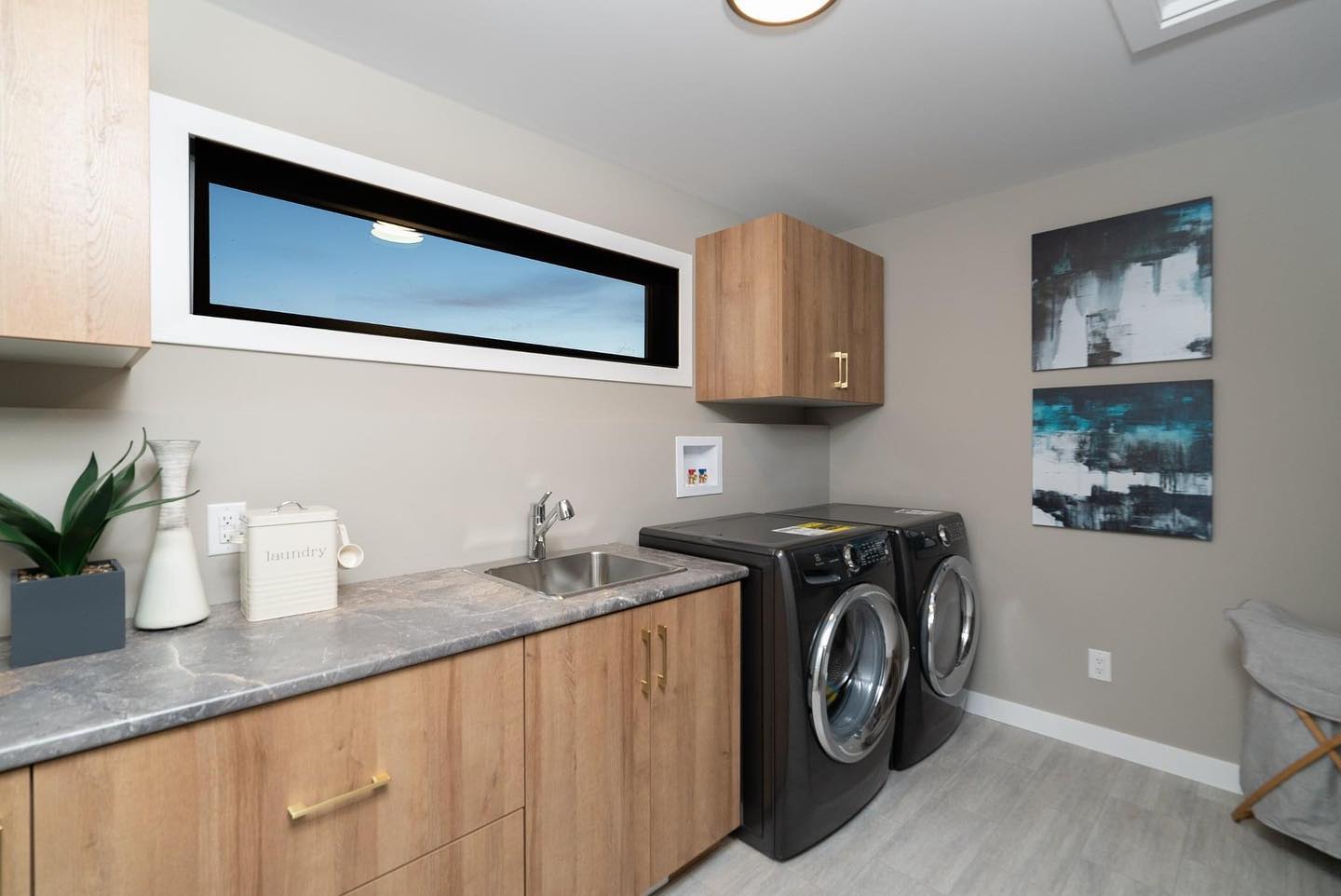 The laundry room is a space that needs to serve the most functionality - plenty of counterspace, drawers/cabinets, and a sink are at the top of the list. 
As a bonus, our Santa Cruz model includes a window to offer you some daylight while you fold your laundry (the least favourite household task!)